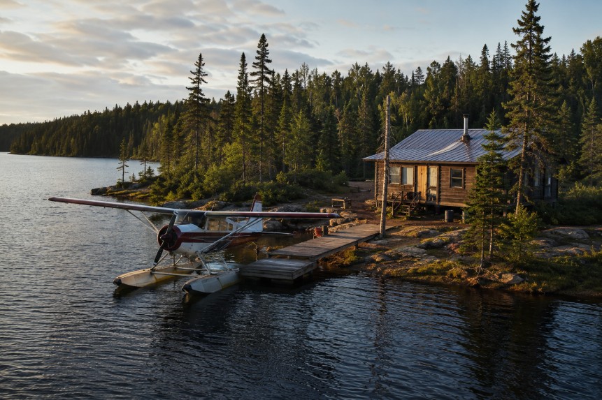 Floatplane docked at a remote fly-in fishing outpost cabin in the boreal forest